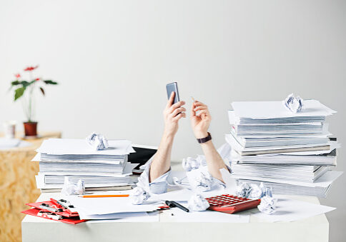 The conceptual image or collage about many of crumpled papers on the desk of stressed male workplace